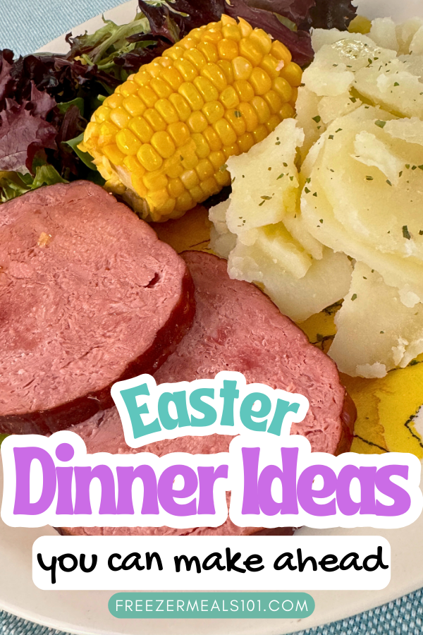sliced ham, corn on the cob, sliced potatoes, and a salad on a plate