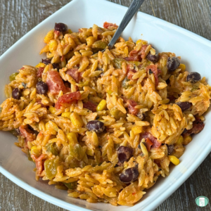 orzo with black beans and tomatoes in a square bowl
