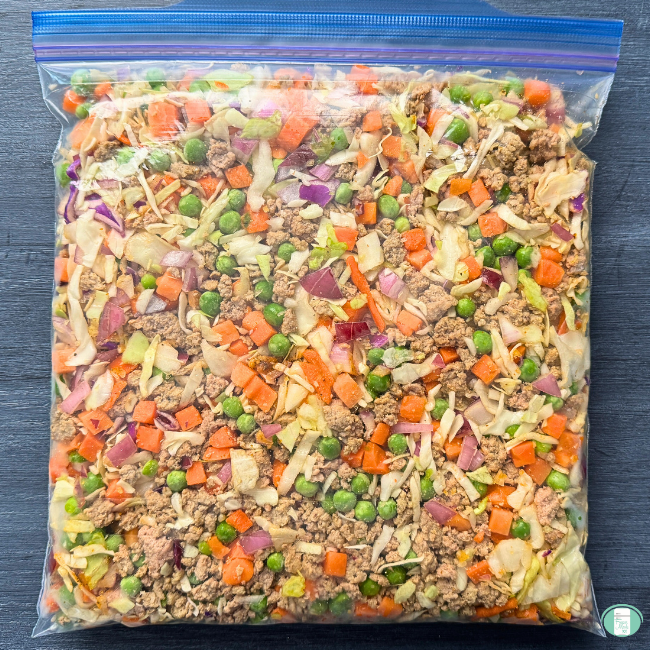 Ground turkey, carrots, peas, onions in clear bag.