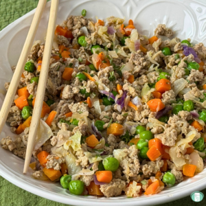 ground turkey, peas, carrots, sliced cabbage in a bowl with chopsticks