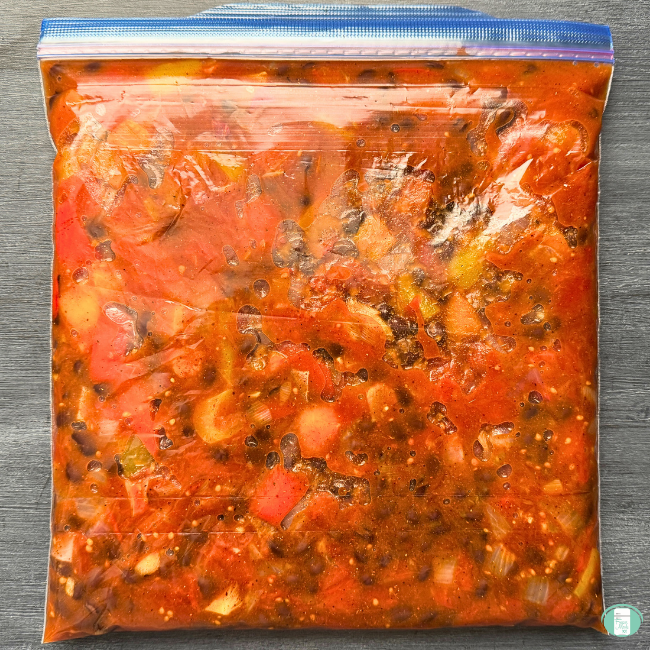 plastic freezer bag filled with vegetables, beans, and red sauce