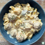 Creamy stroganoff with meatballs served over noodles in a bowl