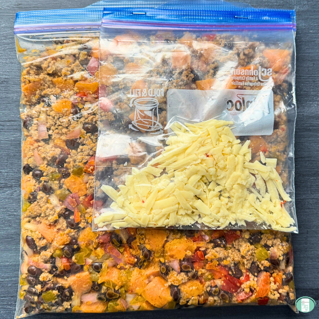 Turkey sweet potato skillet meal with ground turkey, sweet potato, black beans, onion, and seasonings, in a freezer bag, with shredded cheese in a separate bag stapled on top