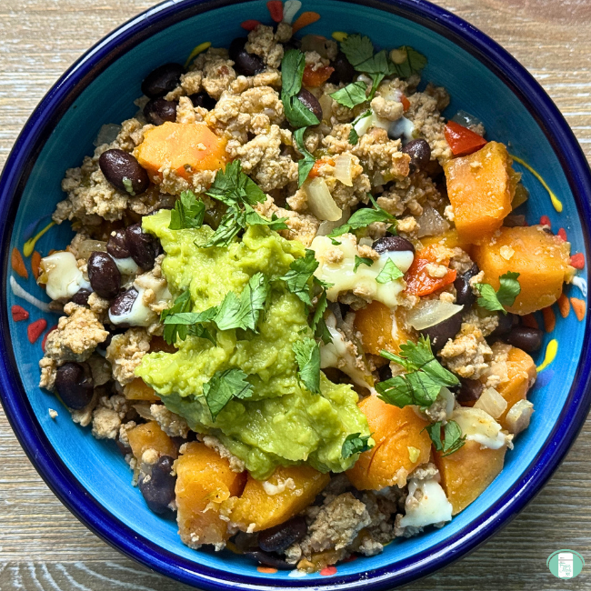 Turkey sweet potato skillet served in a bowl with avocado and cilantro on top
