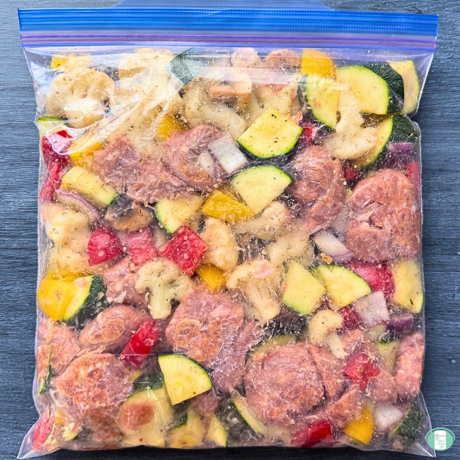 Chicken sausage, zucchini, onion, bell pepper, cauliflower, mushrooms, and seasonings mixed in a ziploc freezer bag 