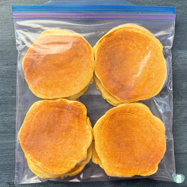 Make-ahead cottage cheese pancakes stacked in a ziploc bag, ready to go in the freezer