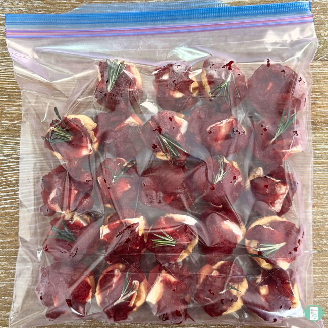 Cranberry brie bite appetizer with cheese, cresent rolls, cranberry sauce, and fresh rosemary in a ziploc bag