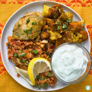 Moroccan Chicken Sheet Pan freezer meal served with quinoa, greek yogurt sauce, lemon, and cilantro